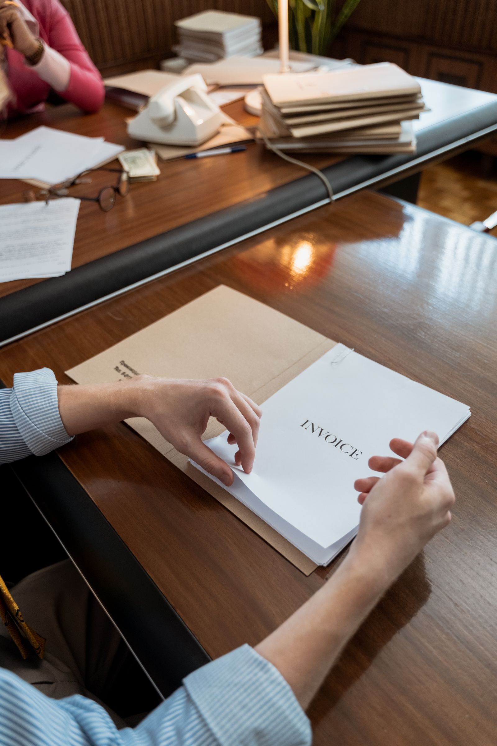 Persona organizando facturas y documentos sobre un escritorio